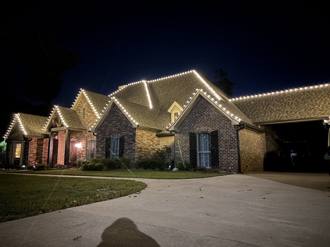 Close view of crisp warm white roofline lights across brick gables